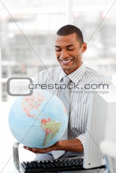 Smiling businessman holding aterrestrial globe