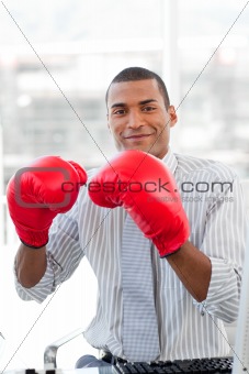 Successful businessman beating the competion with boxing gloves 