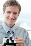 Smiling businessman holding a business card holder