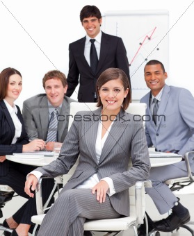 Assertive female executive sitting in front of her team