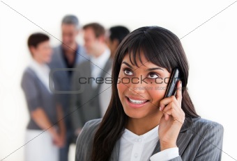 Ethnic businesswoman on phone in front of her team 
