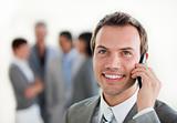 Young businessman on phone in front of his team 
