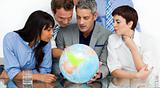 International business people looking at a terrestrial globe 