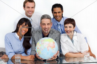 Confident business partners holding a globe 