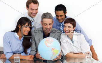 Smiling multi-ethnic business partners holding a globe 