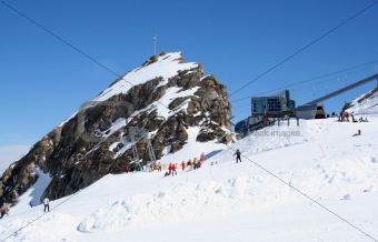 Skiers and lift on Alps mountains