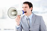 Portrait of an angry businessman using a megaphone 