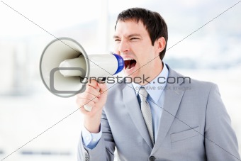 Portrait of an angry businessman using a megaphone 