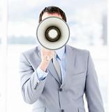 Portrait of an young businessman using a megaphone 