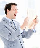 Portrait of a positive businessman reading a newspaper 