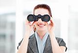 Attractive businesswoman using binoculars 