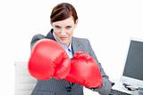 Confident businesswoman punching with boxing gloves 