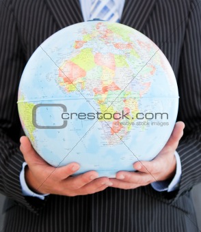Close-up of a charismatic businessman holding a globe 