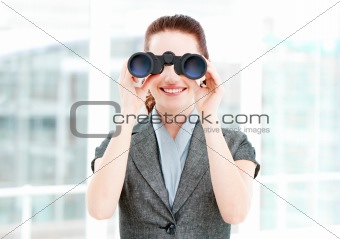 Pretty businesswoman using binoculars 