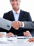 Close-up of a handshake between two businesspeople in front of t