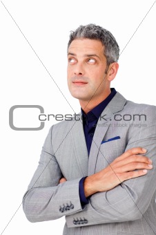 Businessman with folded arms looking up 