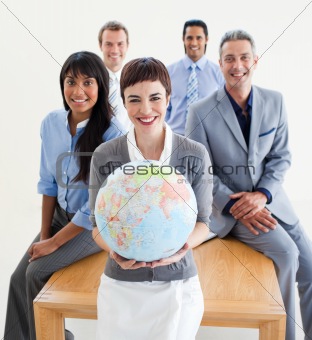 Cheerful multi-ethnic business people holding a terrestrial glob