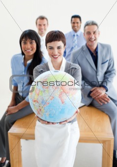 Smiling business team holding a terrestrial globe