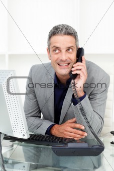 Attractive businessman on phone at his desk 