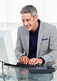 Positive businessman working at a computer 