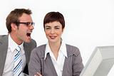 Young businessman shouting into his colleague's ear 