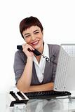 Joyful Businesswoman holding a telephone at her desk 