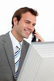 Charming businessman on phone at a computer 