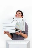 Laughing businesswoman carrying a pile of folders 