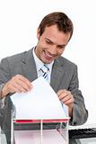 Smiling young businessman studying a document