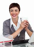 Charming Female executive drinking a coffee at her desk 