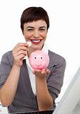 Joyful Female executive saving money in a piggybank