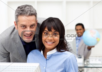 Smiling co-workers working together at a computer