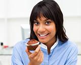 Close-up of a young businesswoman eating a muffin 
