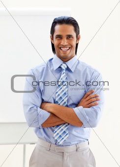 Cheerful ethnic businessman in front of a board 