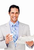 Smiling businessman driking coffee and reading a newspaper 