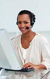 Afro-american businesswoman with headset on working at a compute