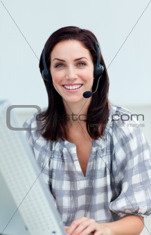Confident businesswoman with headset on working at a computer