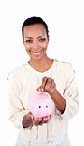 Charming businesswoman saving money in a piggybank 