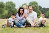 Portrait of happy family of five on the green land