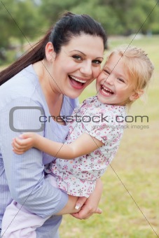 Curious mother carrying her daughter with big smile