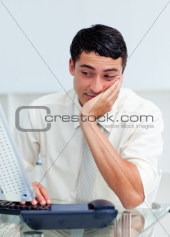 Positive businessman working at a computer in the office