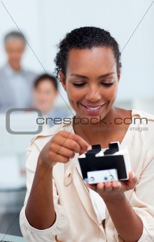 Smiling businesswoman consulting a business card holder