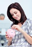 Glowing businesswoman saving money in a piggy-bank