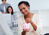 Confident businesswoman saving money in a piggy-bank