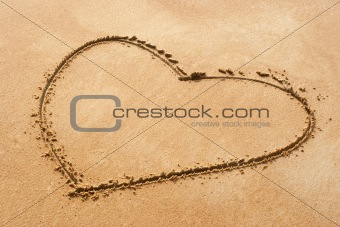 Heart shape symbol on sandy beach