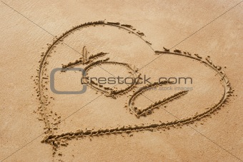 Heart shape symbol with the word you on sandy beach