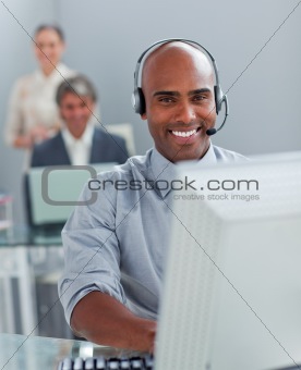 Confident  businessman with headset on working at a computer