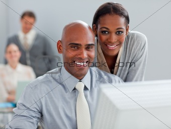 Charismatic businesswoman helping her colleague at a computer