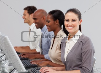 International business people in a line working at computers 