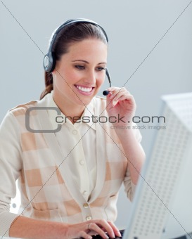 Smiling businesswoman working at a computer with headset on